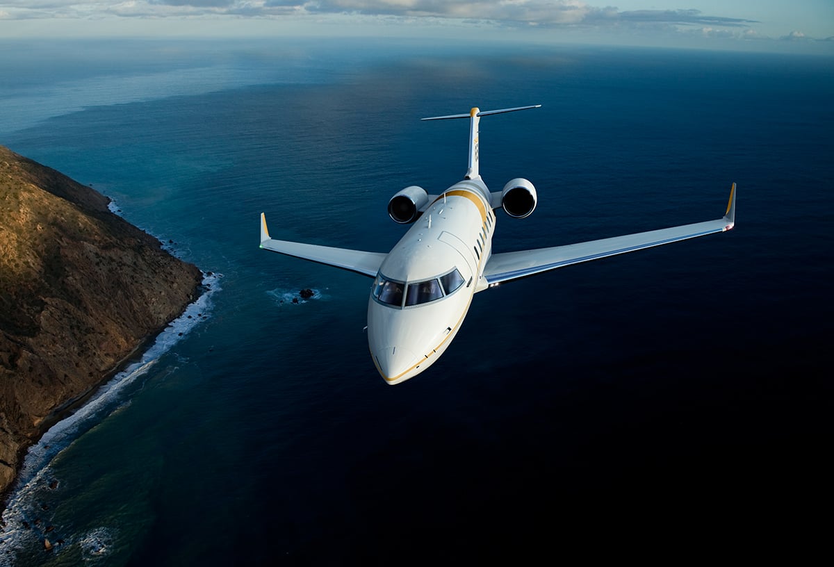 bombardier challenger 650 in flight over water